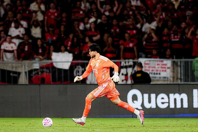 Rossi moves with the ball in an orange kit.